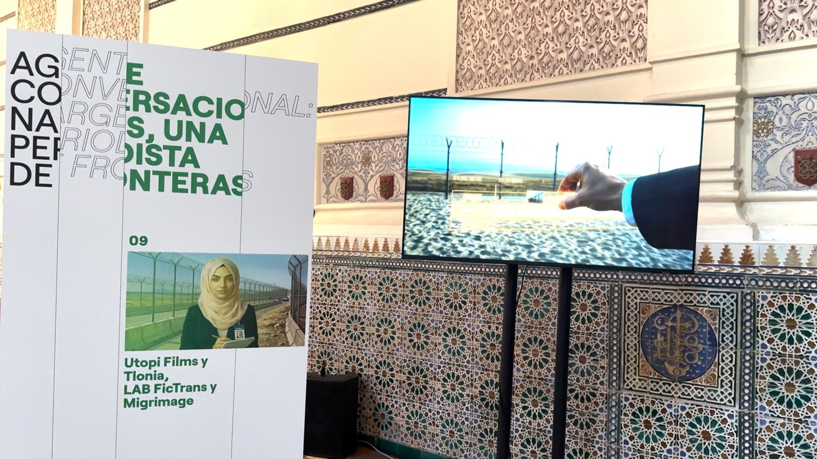 Agente conversacional de la periodista junto a la pantalla del cortometraje en la Capilla Neomudéjar de Granada